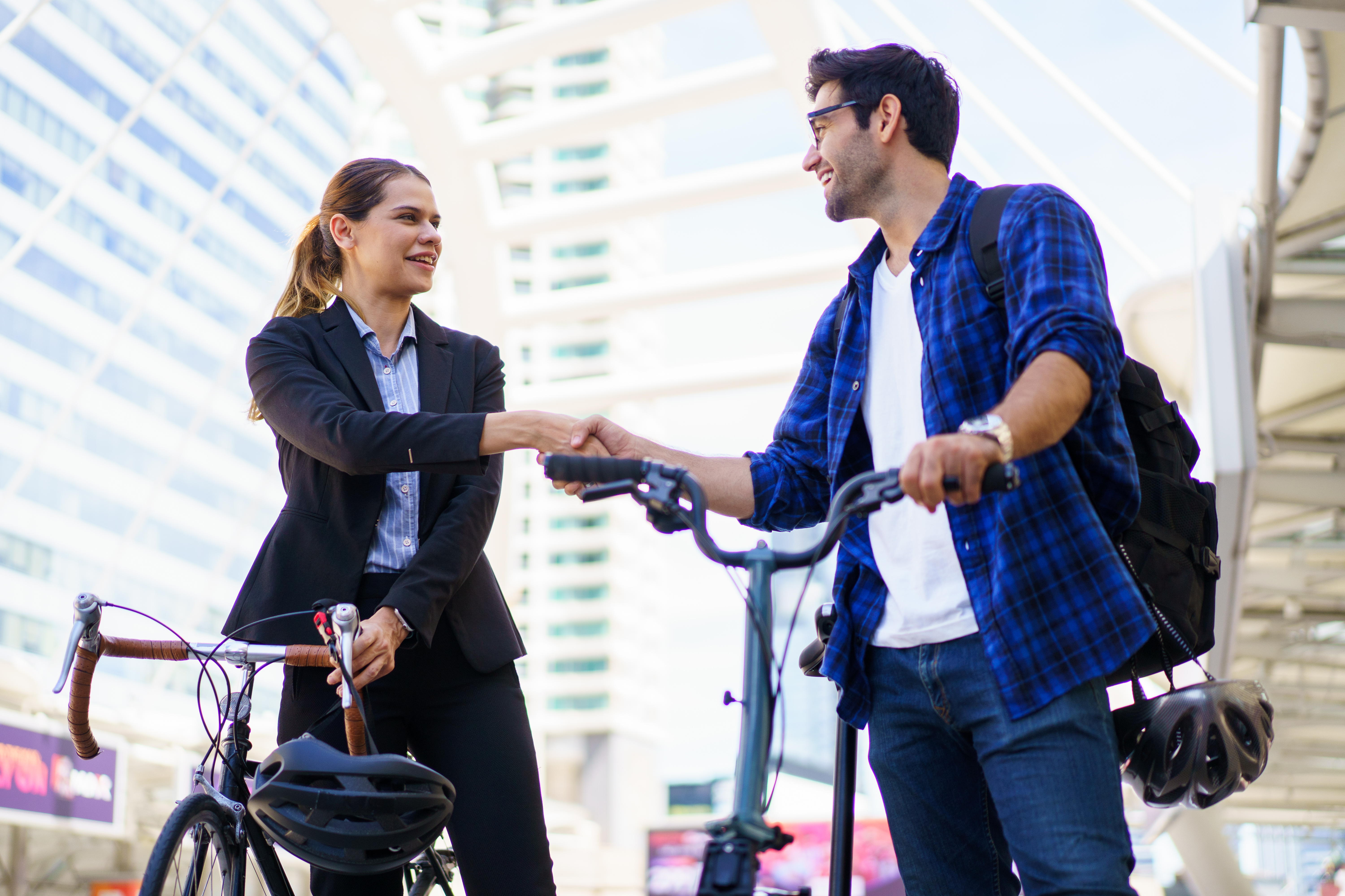 Asian man walking bike with female friend cycling