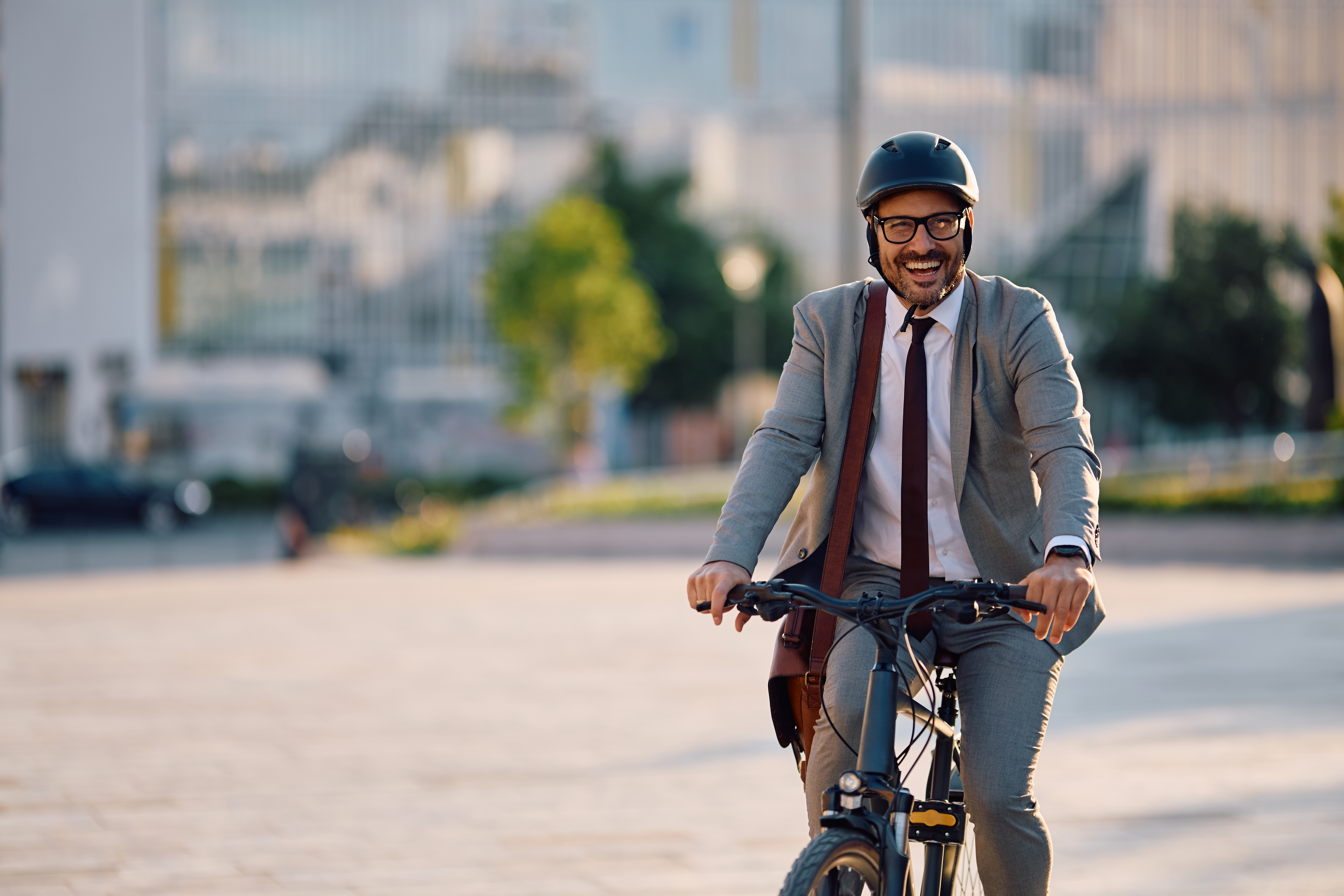 Cheerful entrepreneur riding bicycle in the city