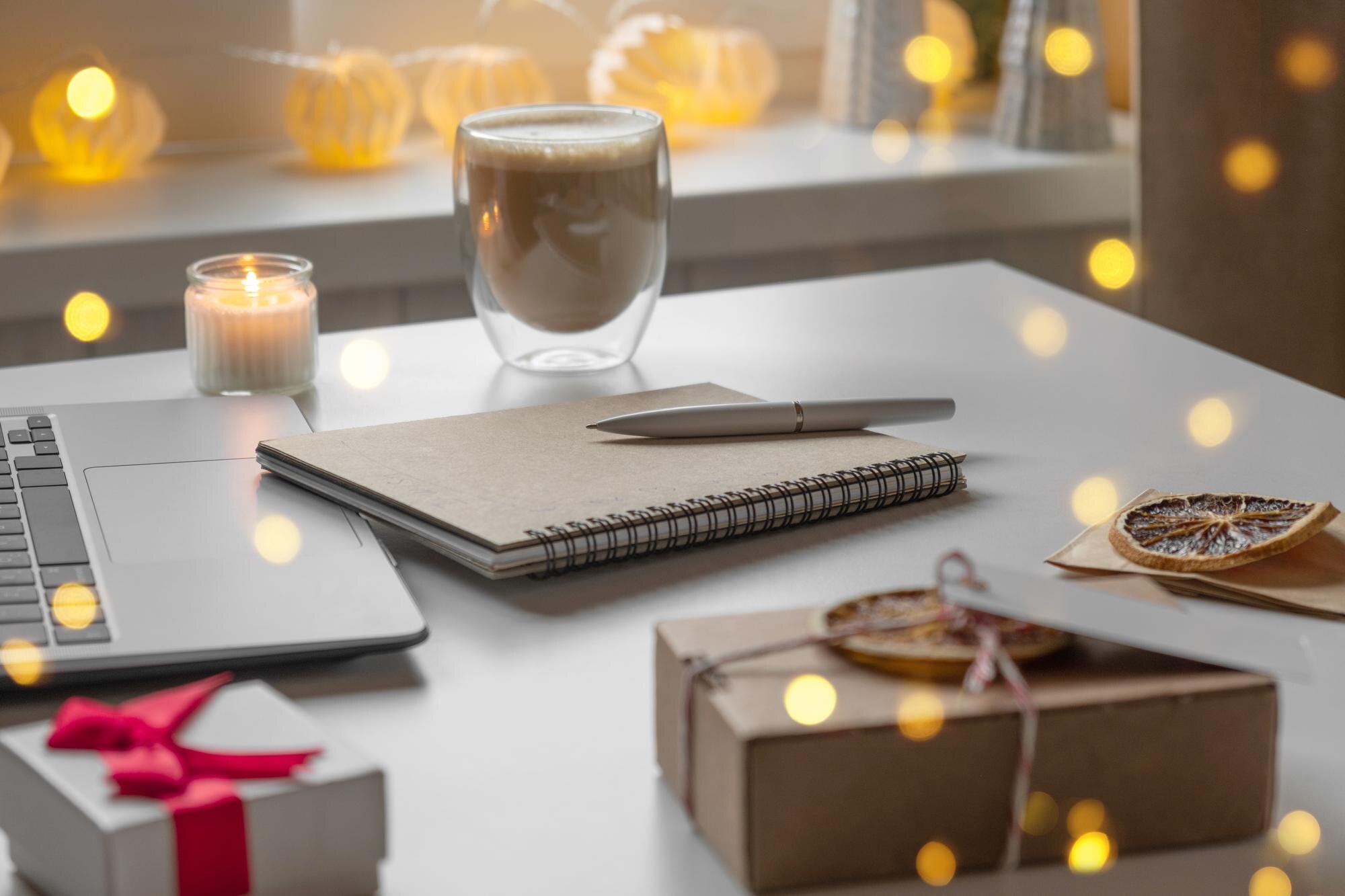 Notepad with a pen laptop coffee cup wrapped gifts