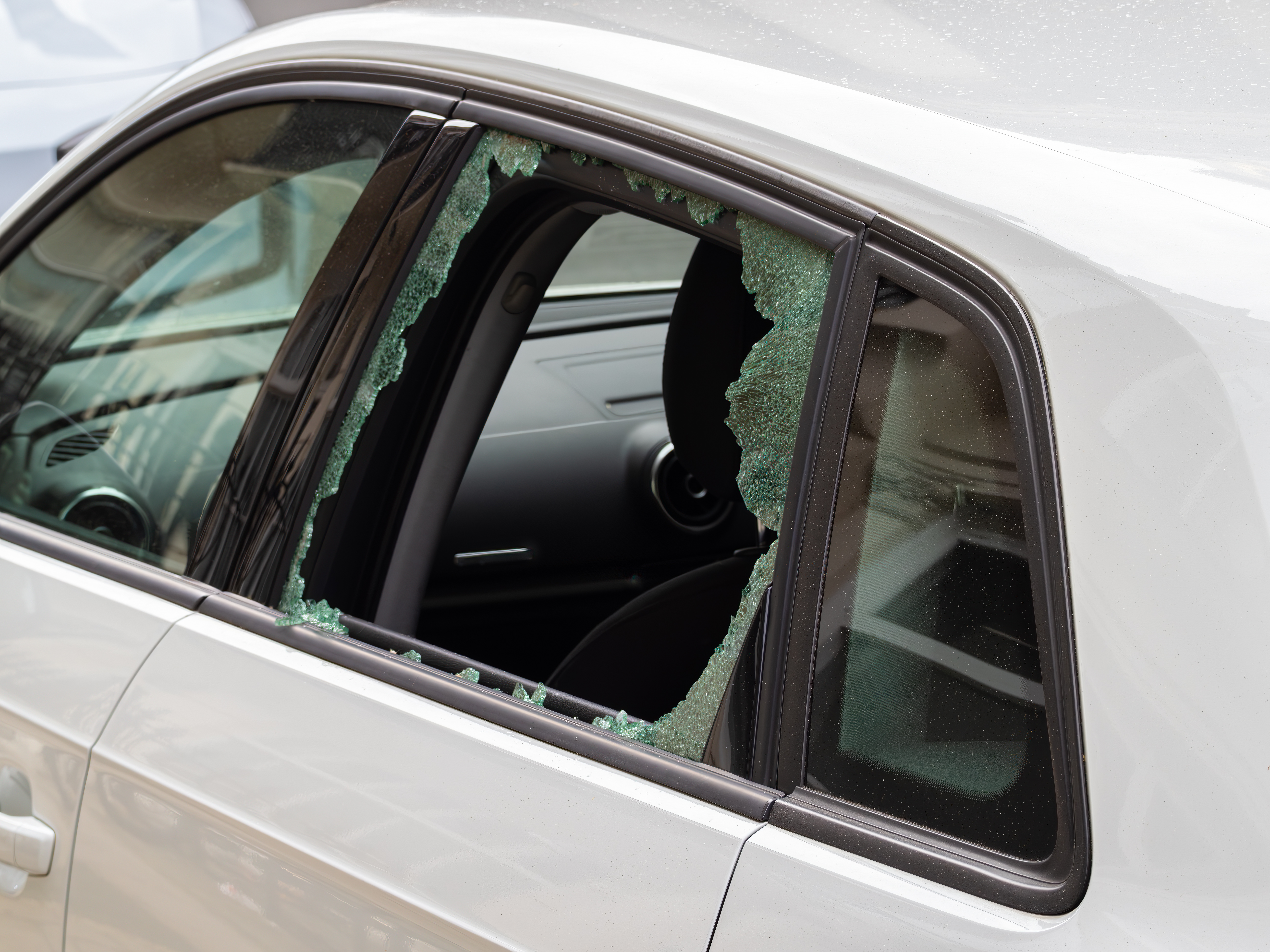 Broken car window with shattered glass