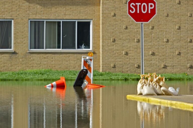 Flooded residential street with a stop sign after heavy storms in the DMV area