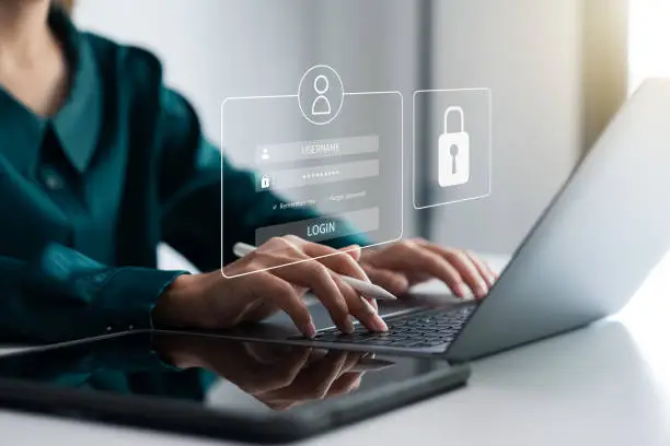 Person reviewing bank statements on a laptop, symbolizing awareness and protection from online fraud.